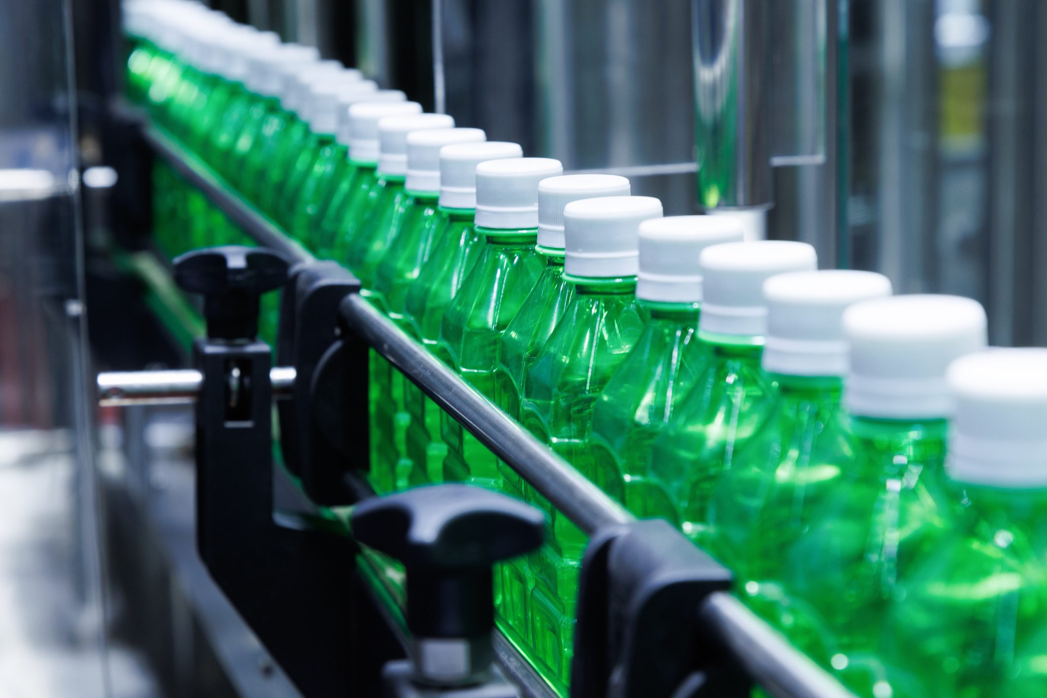 transparent plastic bottles on the conveyor belt moving very fast into water filling machine in the drinking water factory. beverage industry.